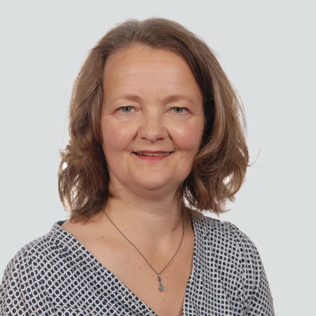 Friederike Scholz blickt auf dem Bild freundlich in die Kamera. Ihre Haltung und Mimik vermitteln Engagement.
